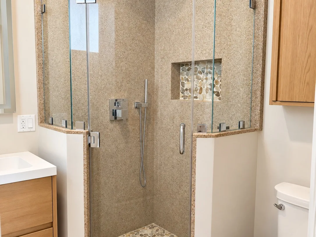 Finished ADU shower with stacked green tile and brass fixtures