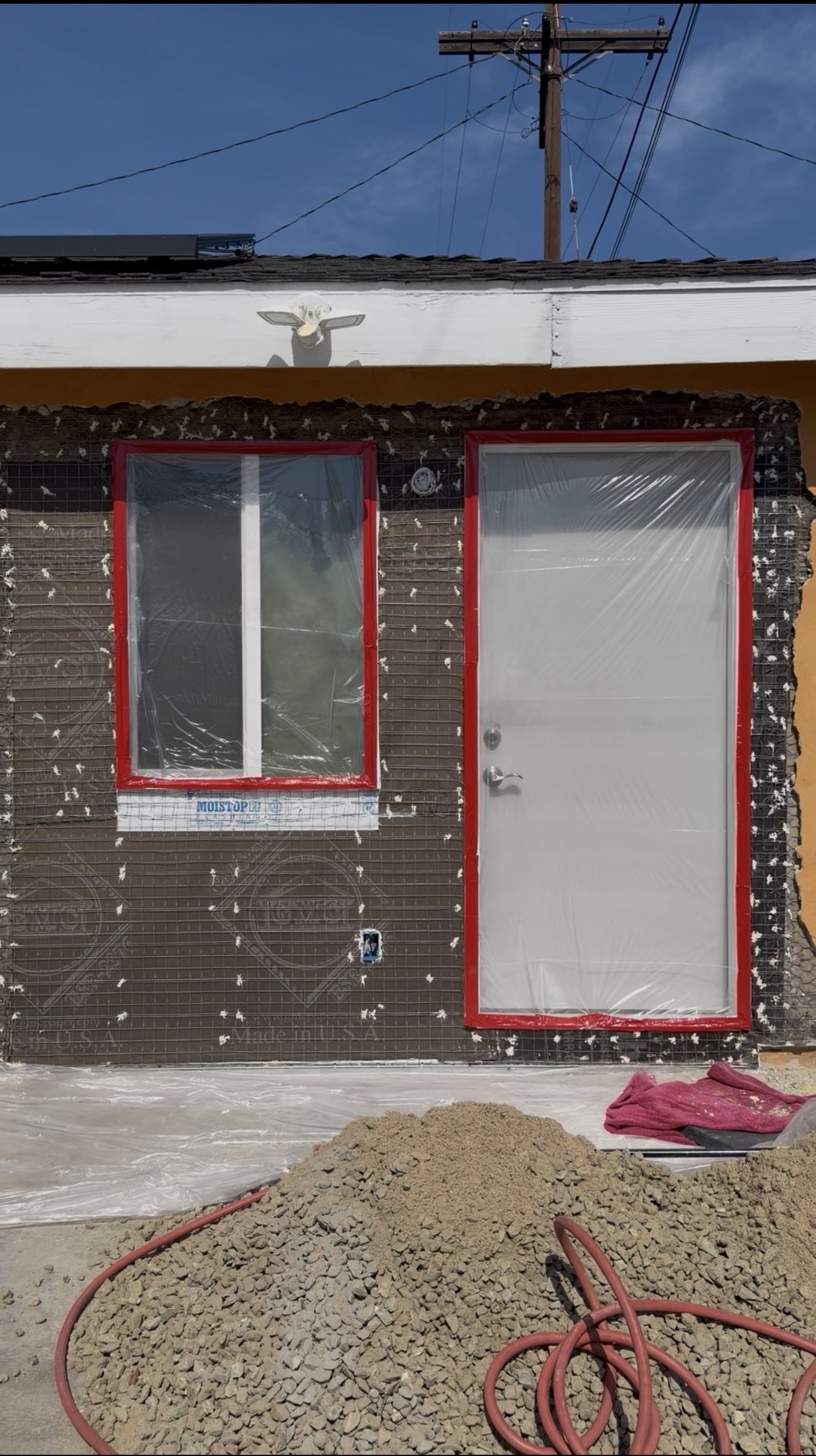 ADU exterior with new window and door cutouts during lath prep
