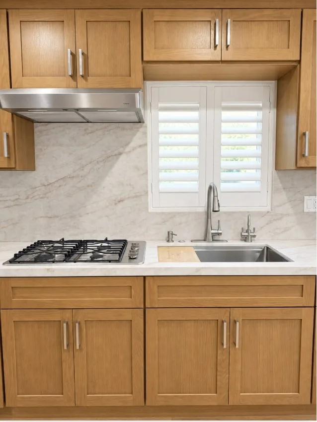 Finished ADU kitchen counter with stone backsplash and plantation shutters