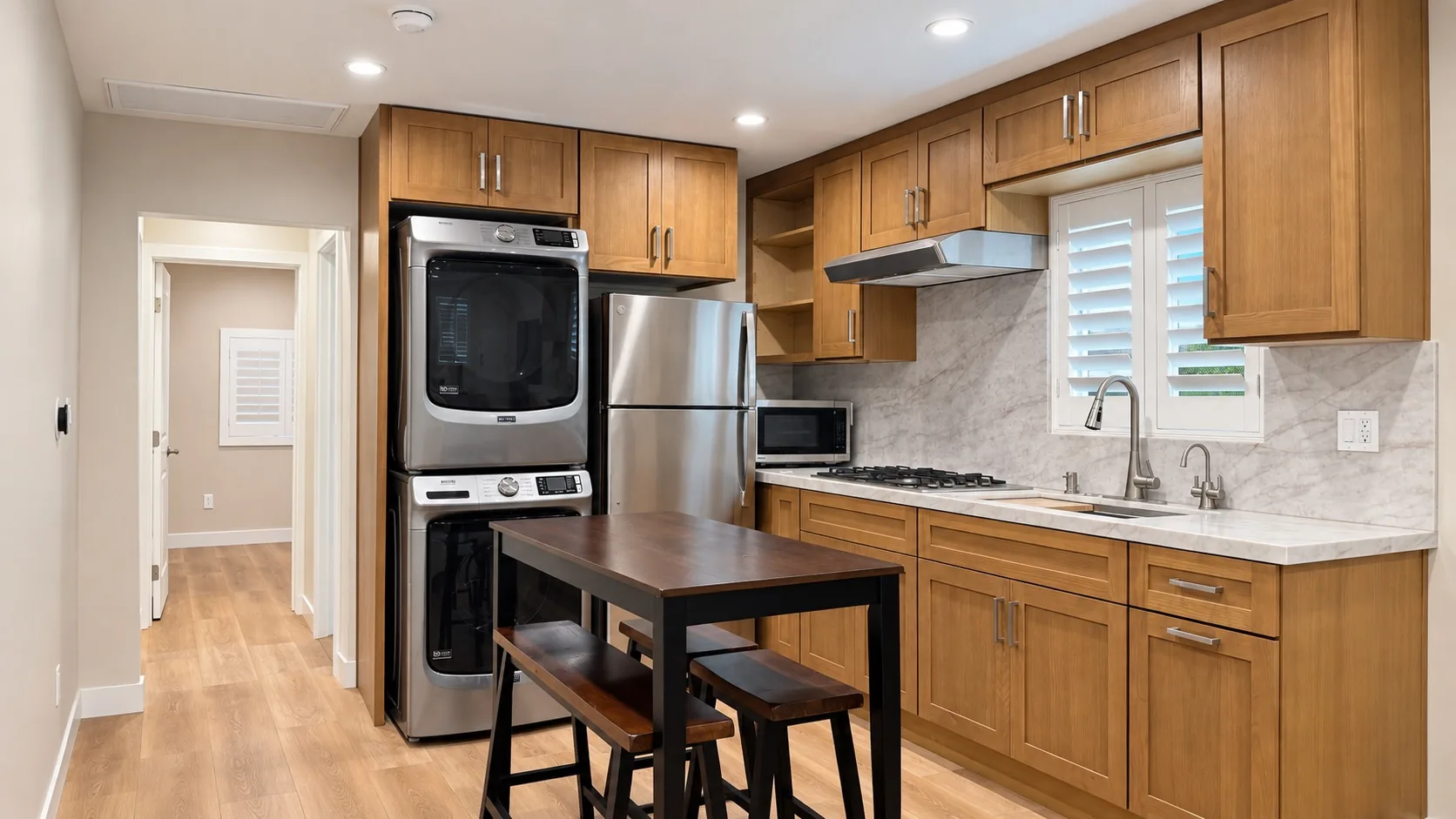 Finished ADU kitchen with range, refrigerator and stacked laundry