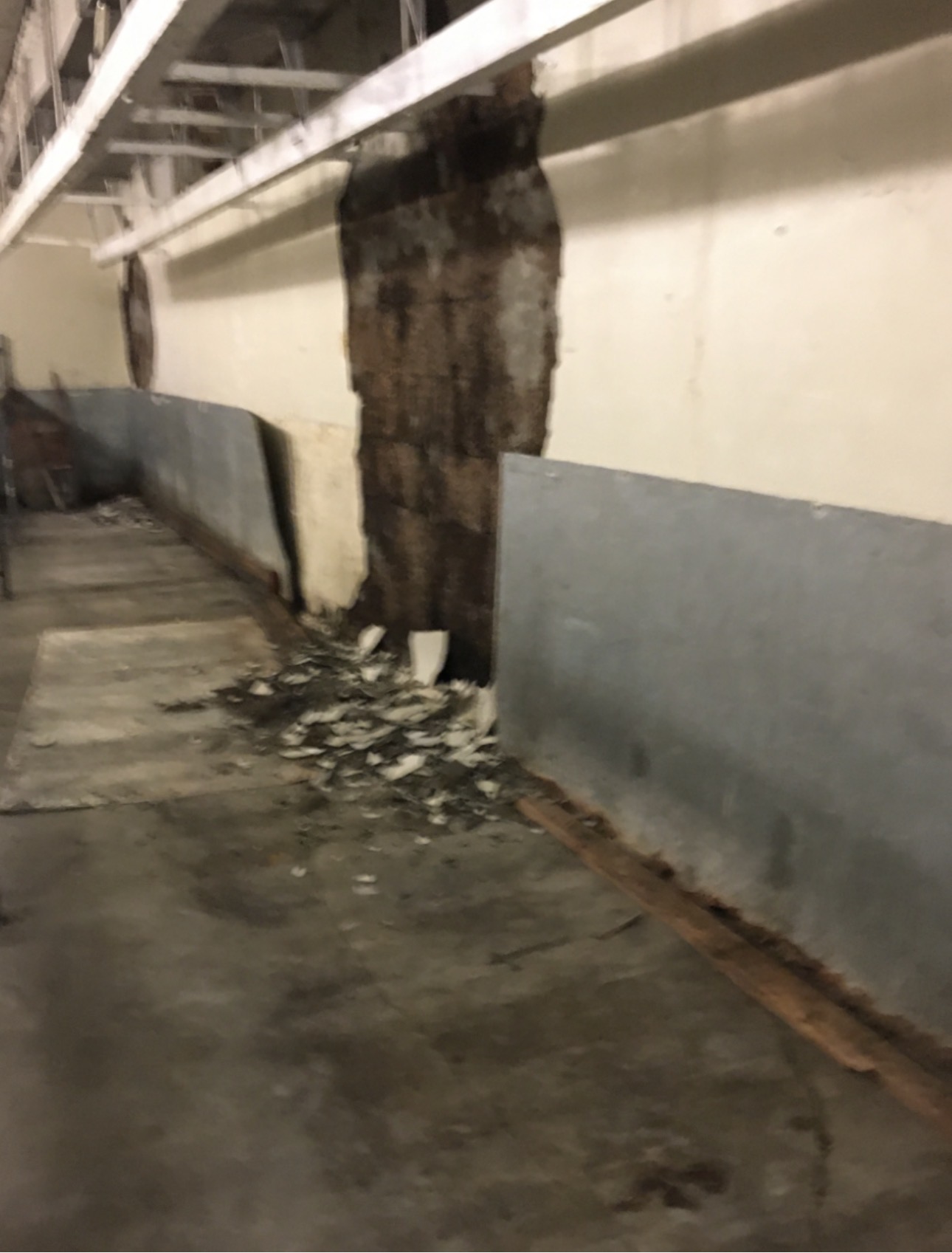 Deteriorated cork insulation inside commercial walk-in refrigeration unit before restoration