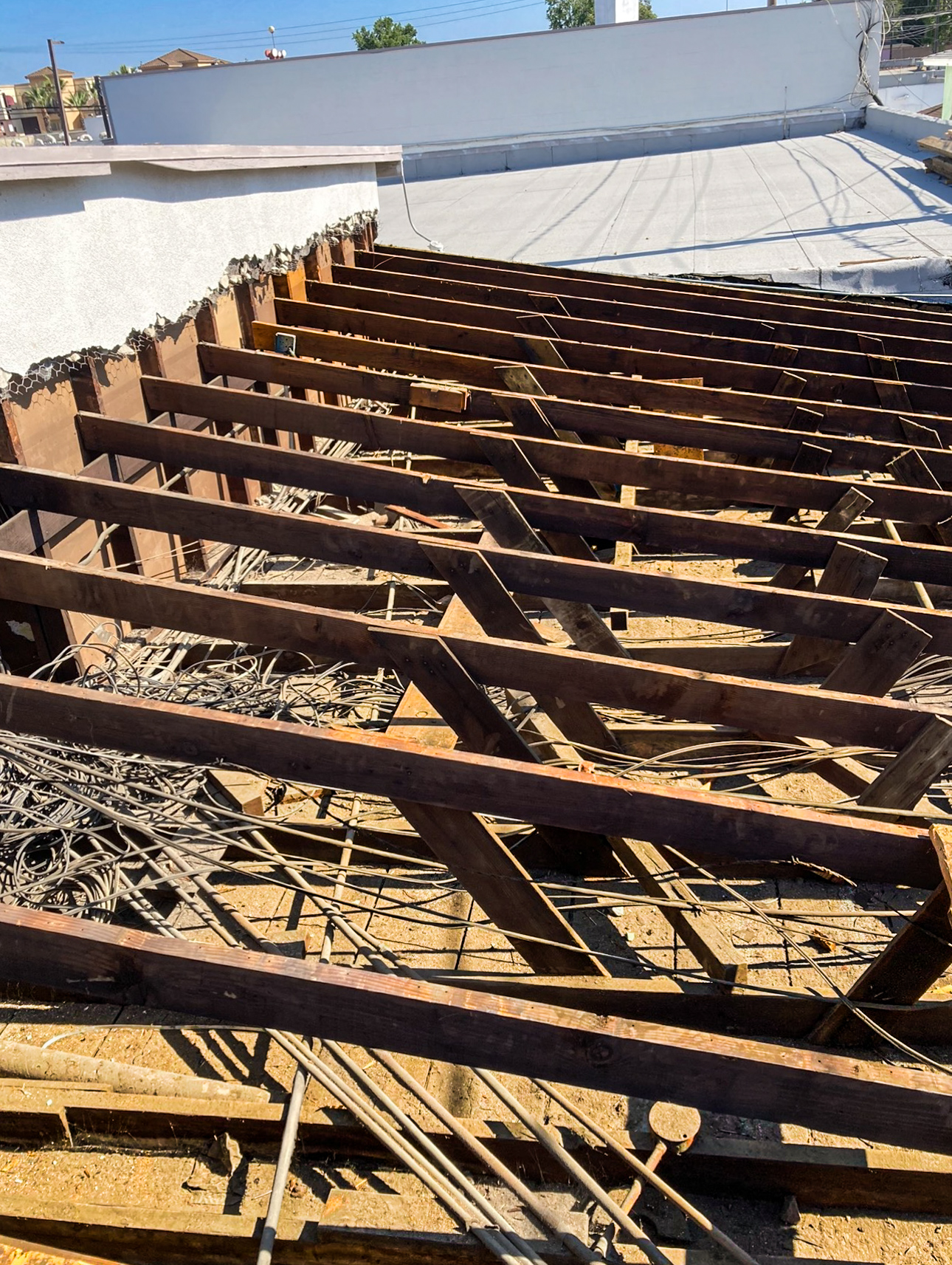 Flat roof tear-off exposing bare joists and structural damage