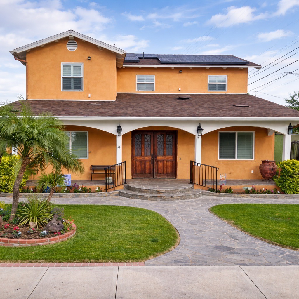 Completed two-story residential addition with stucco exterior, stone walkway, and landscaping — front elevation