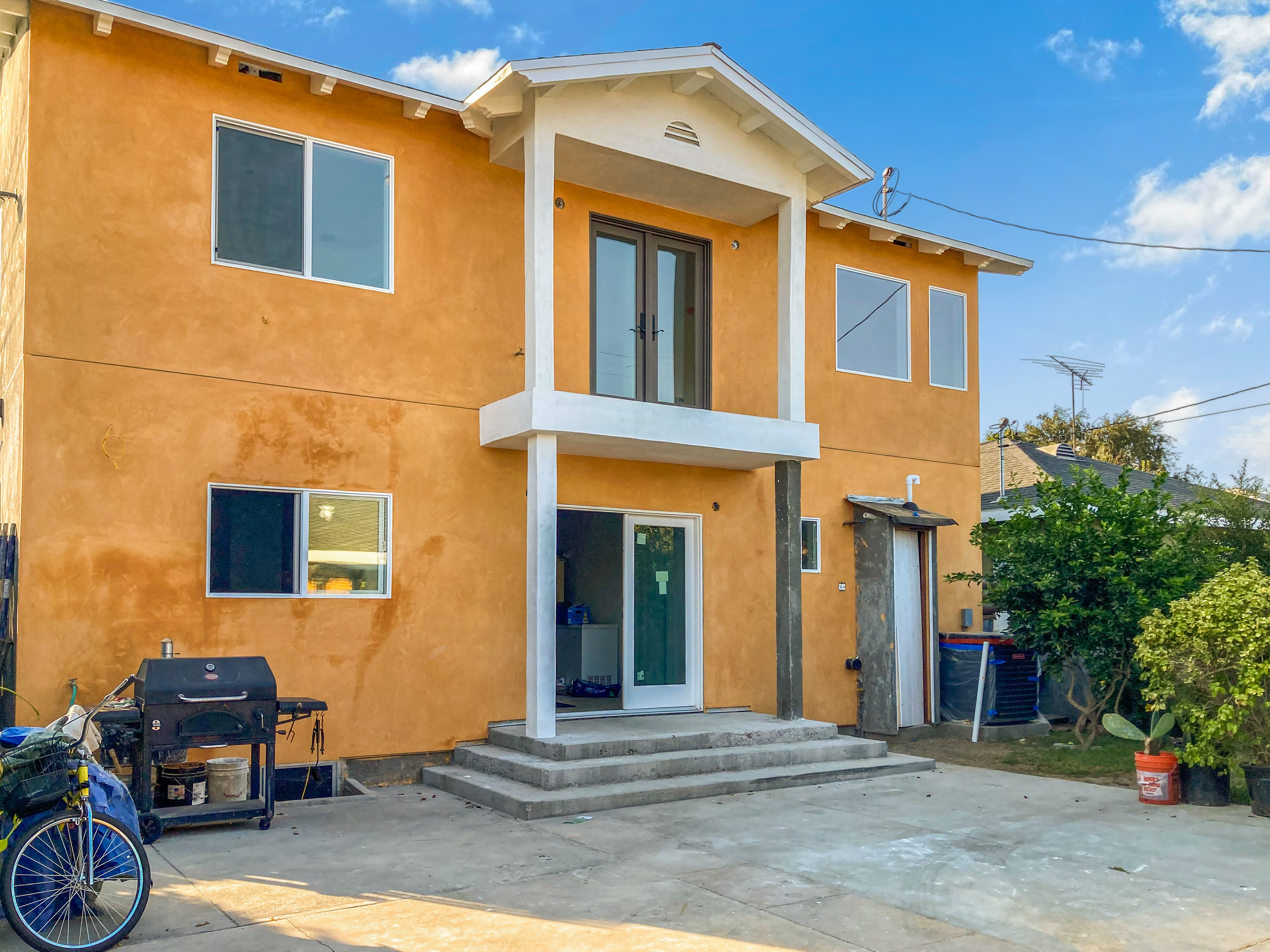 Completed rear elevation with stucco, windows, balcony, and second story