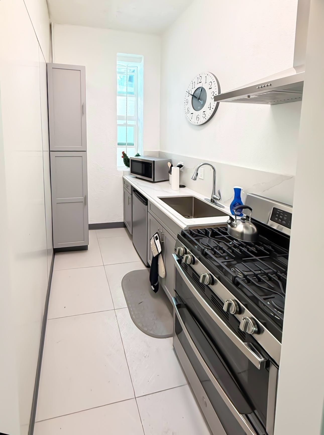 Completed warehouse breakroom kitchen with quartz countertops and stainless appliances in Norwalk